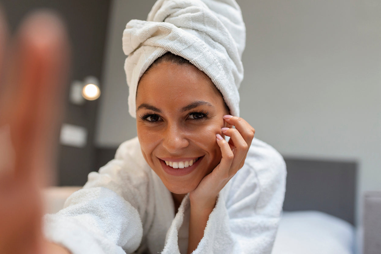 girl smiling at camera with towel on her head, words say that your skin is only happy when your skin microbiome is 